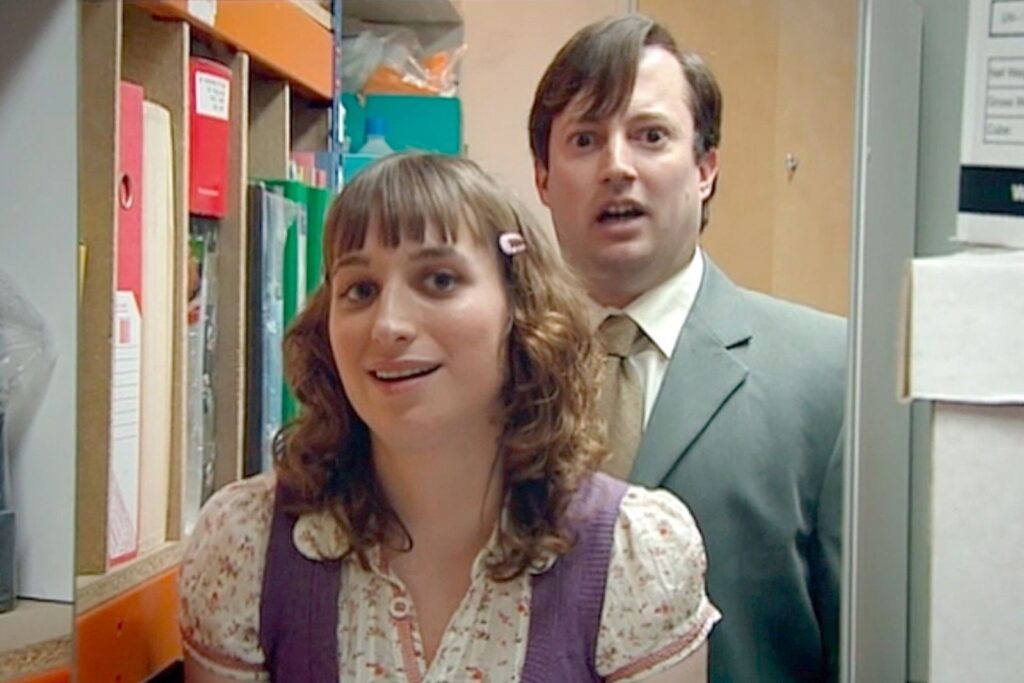 Isy Suttie como Dobbie y David Mitchell como Mark fajando torpemente de perrito en la copiadora en la serie Peep Show.