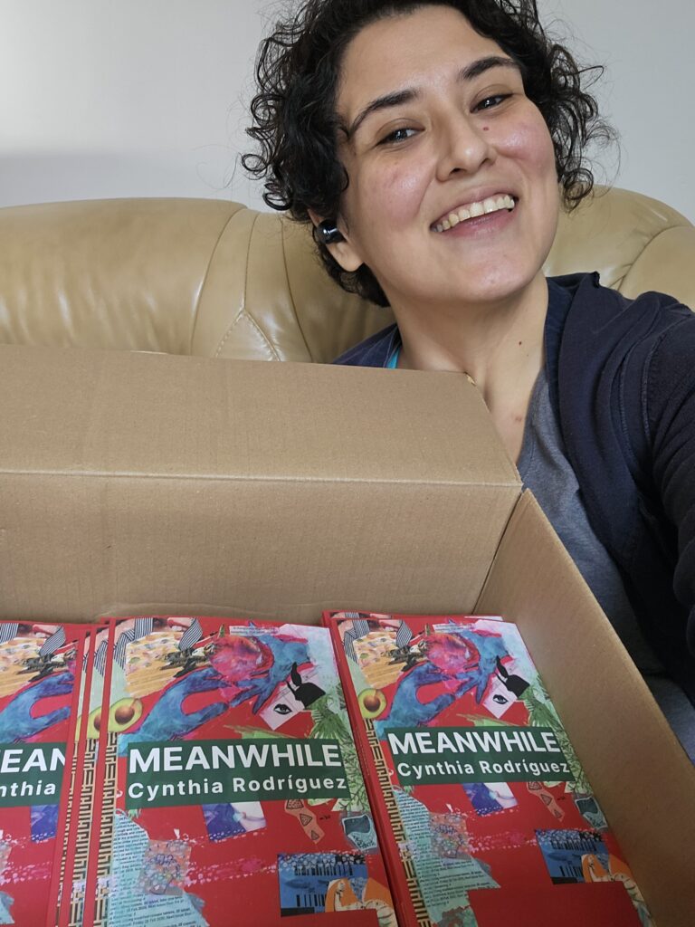 La autora Cynthia Rodríguez Juárez con copias físicas de su libro debut de poesía Meanwhile (Mientras Tanto)
